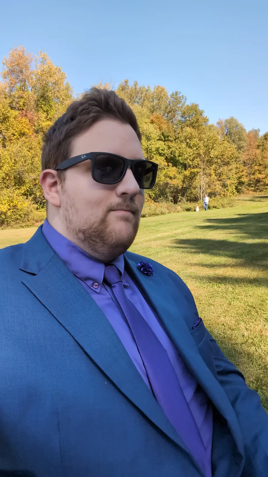 Mark in a blue suit outdoors in autumn