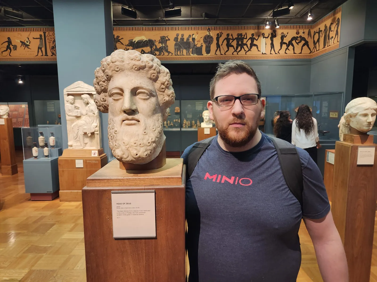 Mark next to a classical marble bust in a museum gallery